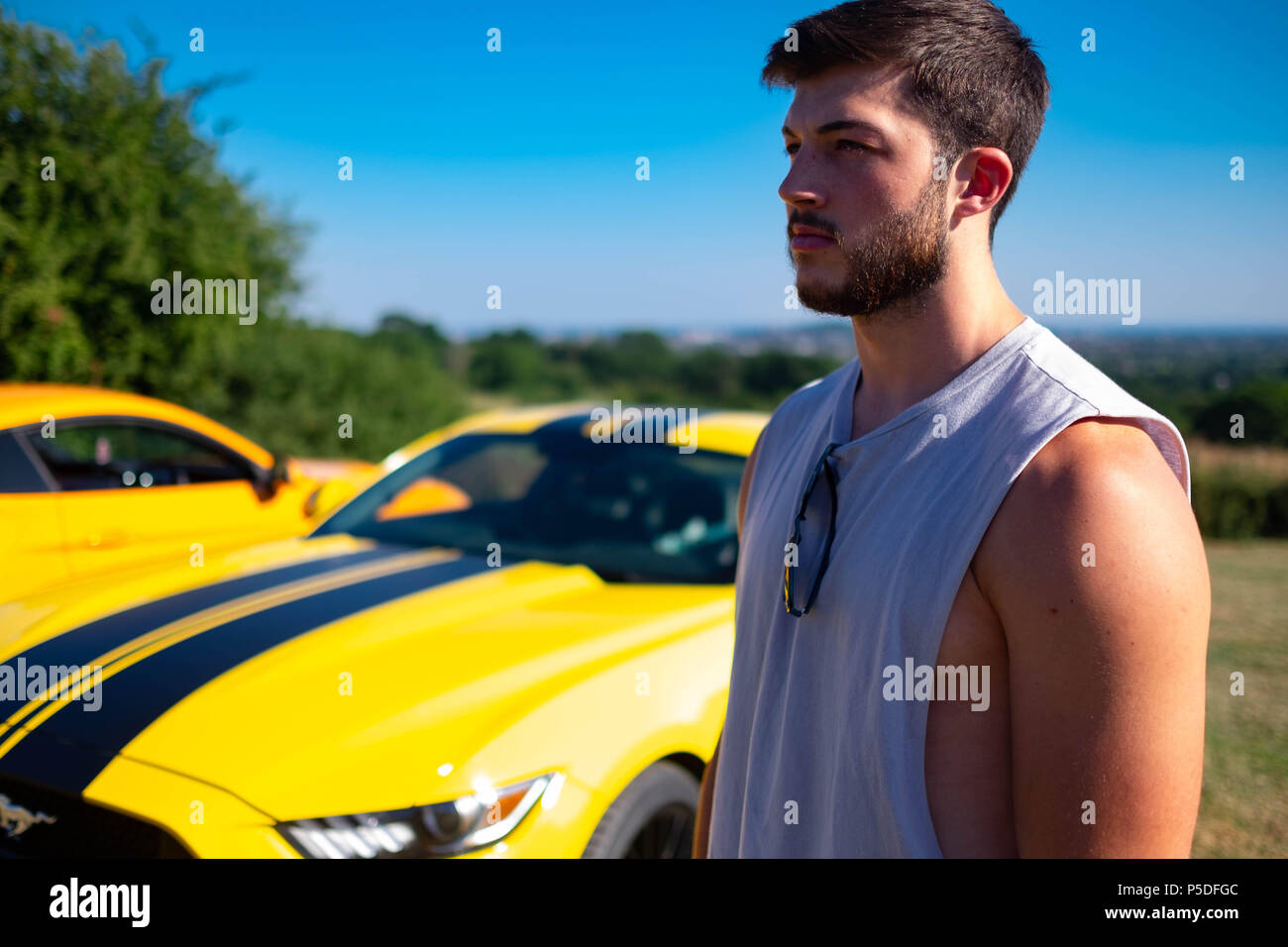 Muskulösen jungen Mann wirft mit 2 Europäischen Ford Mustang 5 Liter V8 GT Fastback Auto Sportwagen in Großbritannien Stockfoto