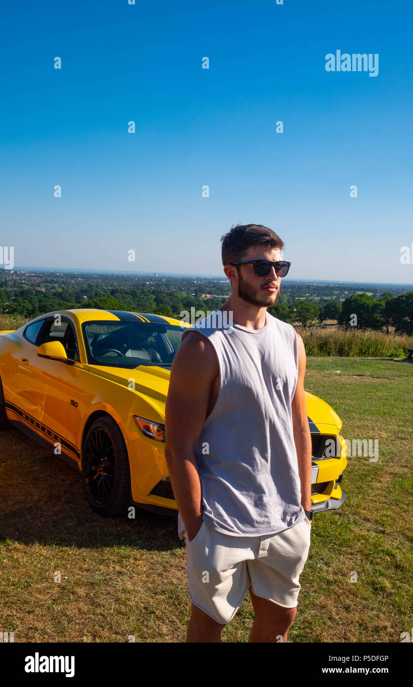 Muskulösen jungen Mann wirft mit einer Europäischen Ford Mustang 5 Liter V8 GT Fastback Auto Sportwagen in Großbritannien Stockfoto