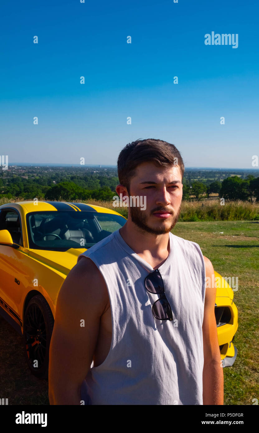 Muskulösen jungen Mann wirft mit einer Europäischen Ford Mustang 5 Liter V8 GT Fastback Auto Sportwagen in Großbritannien Stockfoto