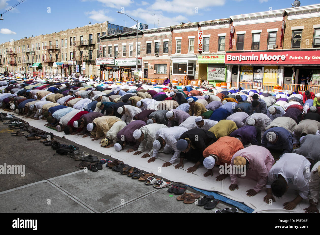 Muslimische Männer beten auf Eid auf McDonald Ave in Brooklyn, NY in der 'Kleine Bangladesch" Kensington Viertel. Eid al-Adha, hat keine bestimmte Zeitdauer und "Fest der Fastenbrechen") ist ein wichtiger religiöser Feiertag gefeiert von Muslimen weltweit, markiert das Ende des Ramadan, des islamischen heiligen Monats fasten (Saum). Stockfoto