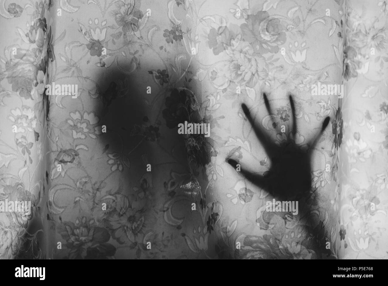 Schwarz-weiß-Bild der geheimnisvollen menschlichen Schatten hinter einem Vorhang. Angst, Mystery, unheimlich, gruselig und paranormale Konzept Stockfoto