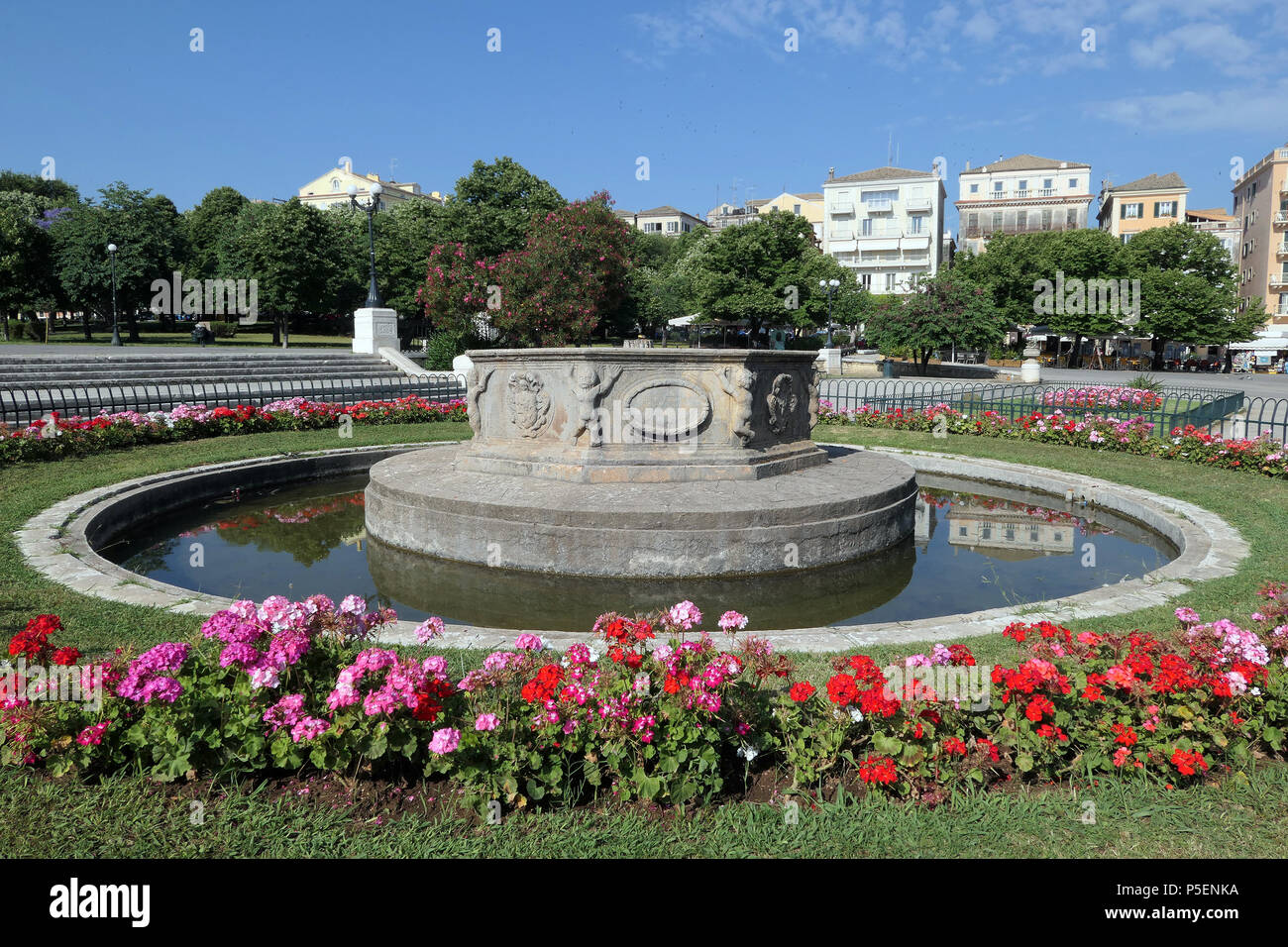 Stadtbild der Altstadt von Korfu Stadt. Brunnen an der Esplanade mit Geranium Beet (Griechenland). Stockfoto