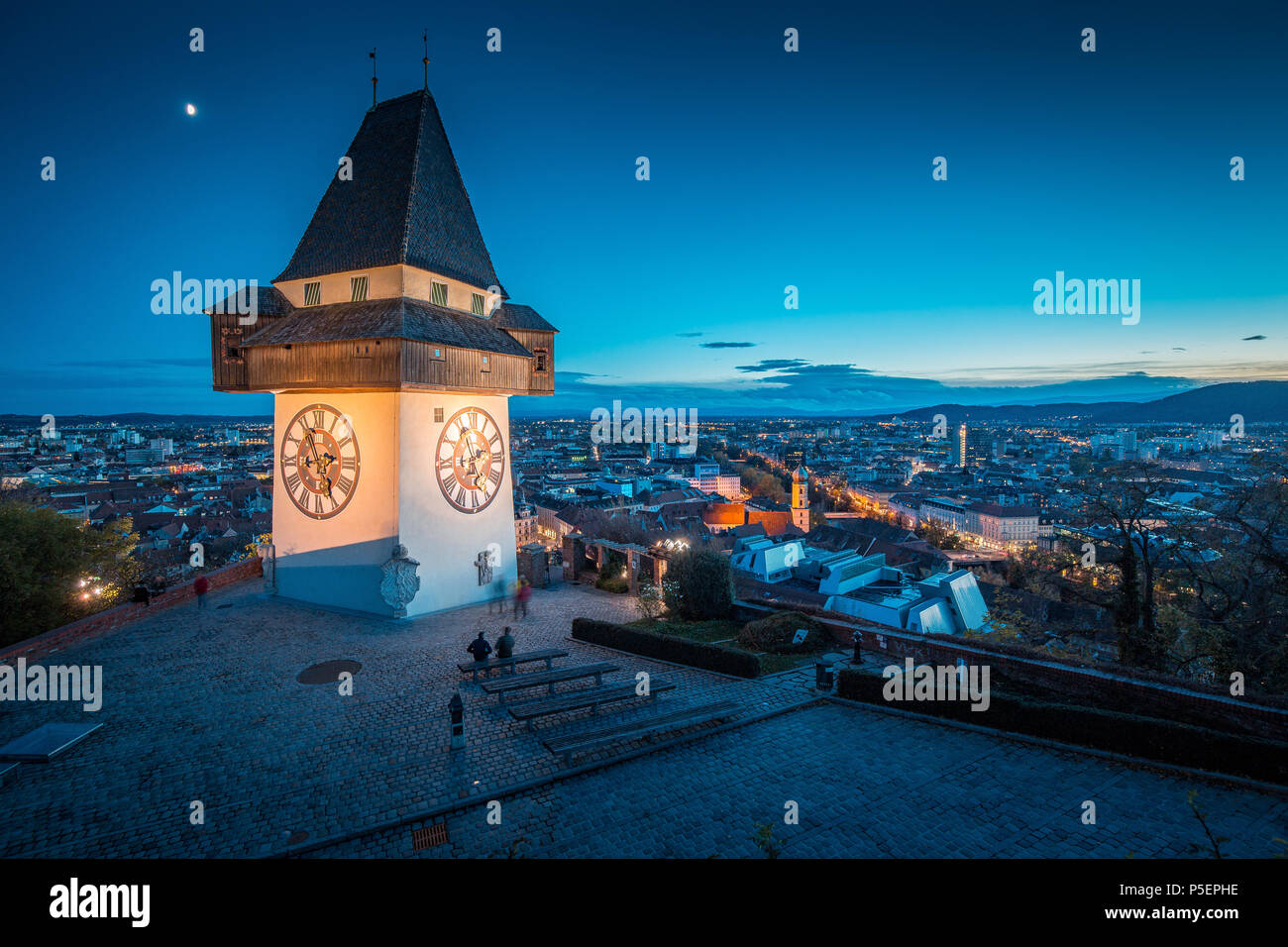 Schöne Dämmerung Blick auf berühmte Grazer Uhrturm (Uhrturm) während der Blauen Stunde in der Dämmerung, Graz, Steiermark, Österreich Stockfoto