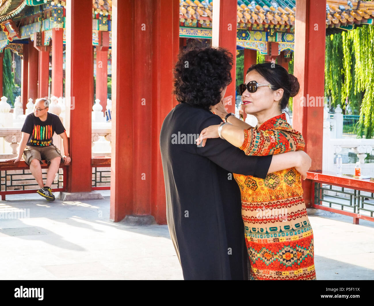 Peking, China - September 2017: Zwei älteren Frauen tanzen als Paar in den Pavillons im Beihai Park bei Sonnenuntergang Stockfoto