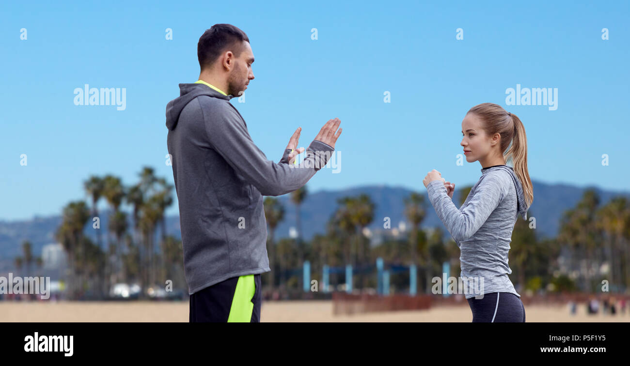 Glückliche Frau mit Trainer arbeiten auf Streik im Freien Stockfoto