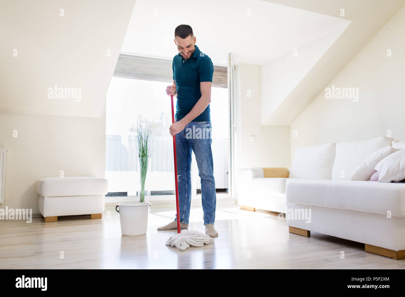 Mann mit Wischmopp und Eimer Reinigung Boden zu Hause Stockfoto