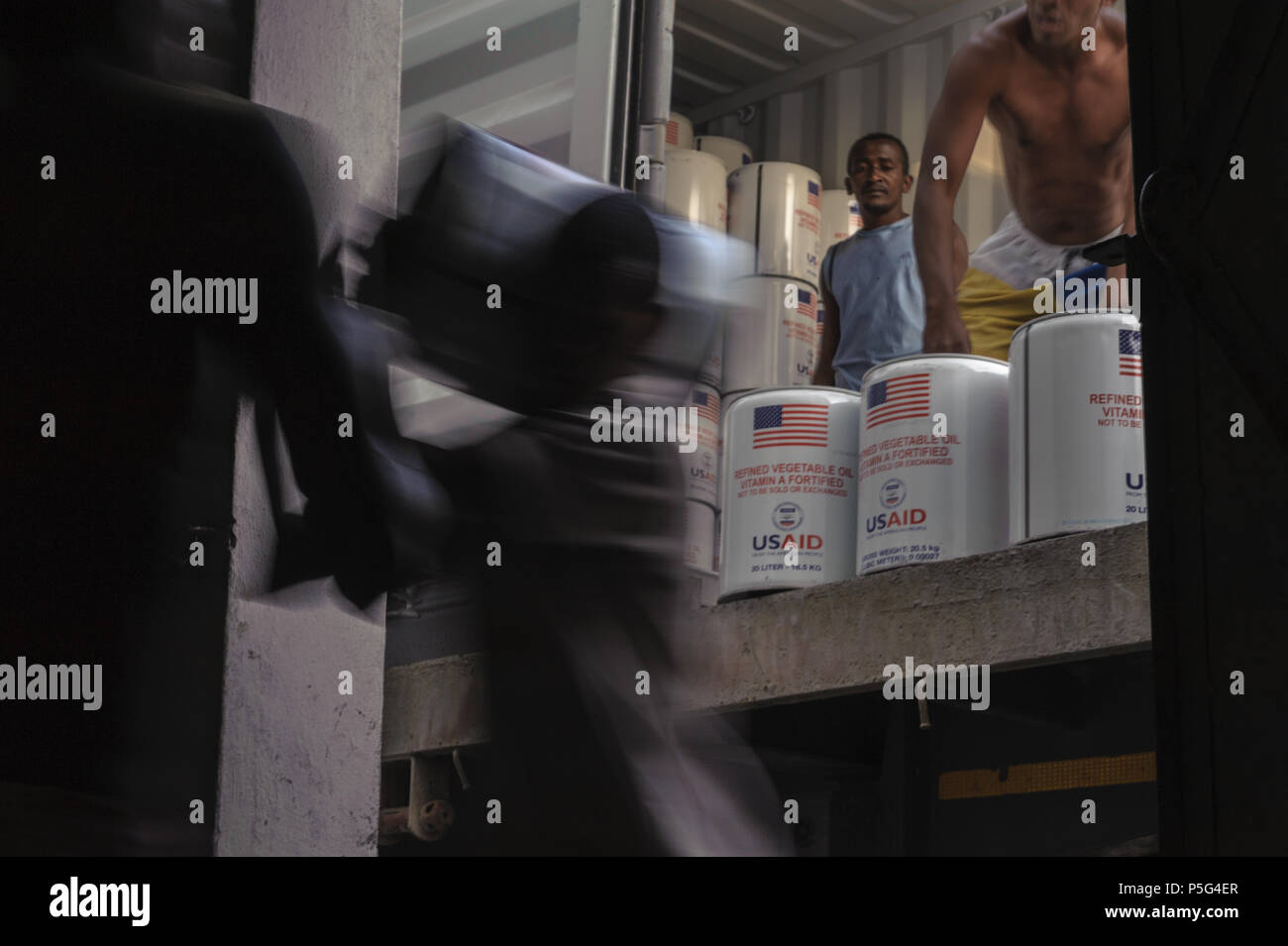 USAID vegetable oil for humanitarian assistance being offloaded into a warehouse in Tolanaro, Madagascar Stockfoto