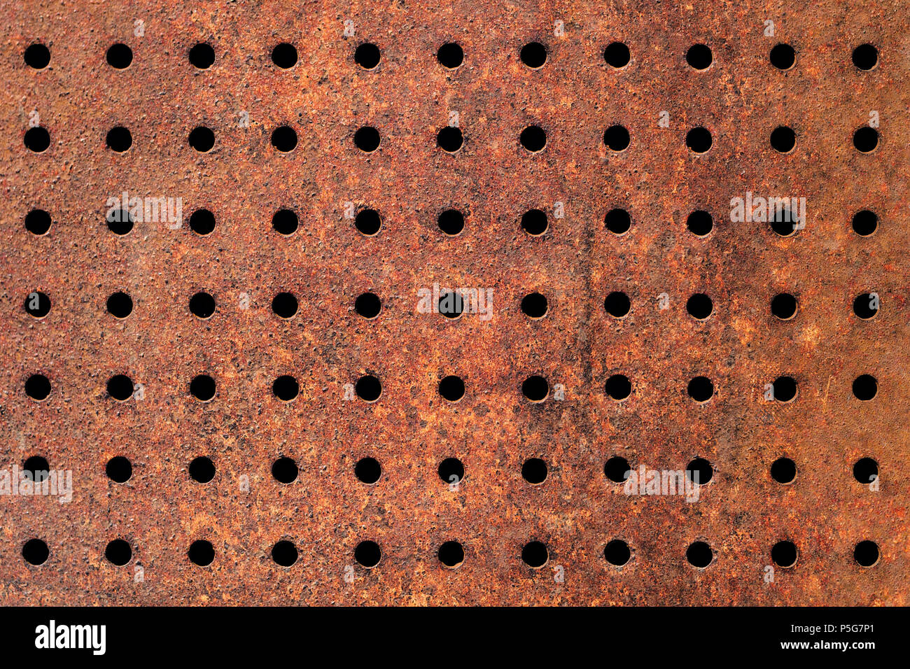 Rostige Textur aus perforiertem Metall mit regelmäßigen Muster der Löcher. Stockfoto