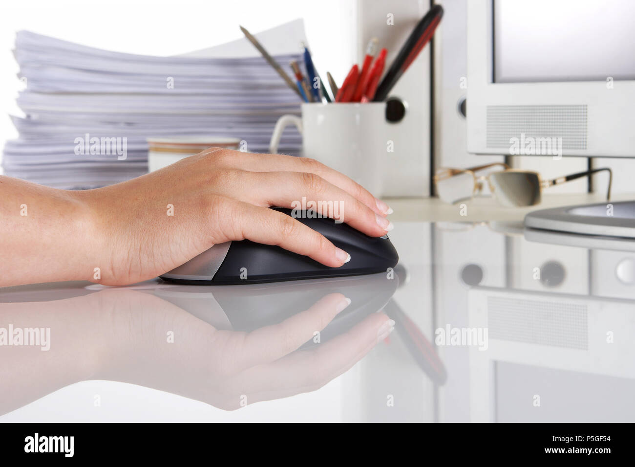 Weibliche Hand auf einem Computer Maus, reflektierende Oberfläche, und Büro Stockfoto