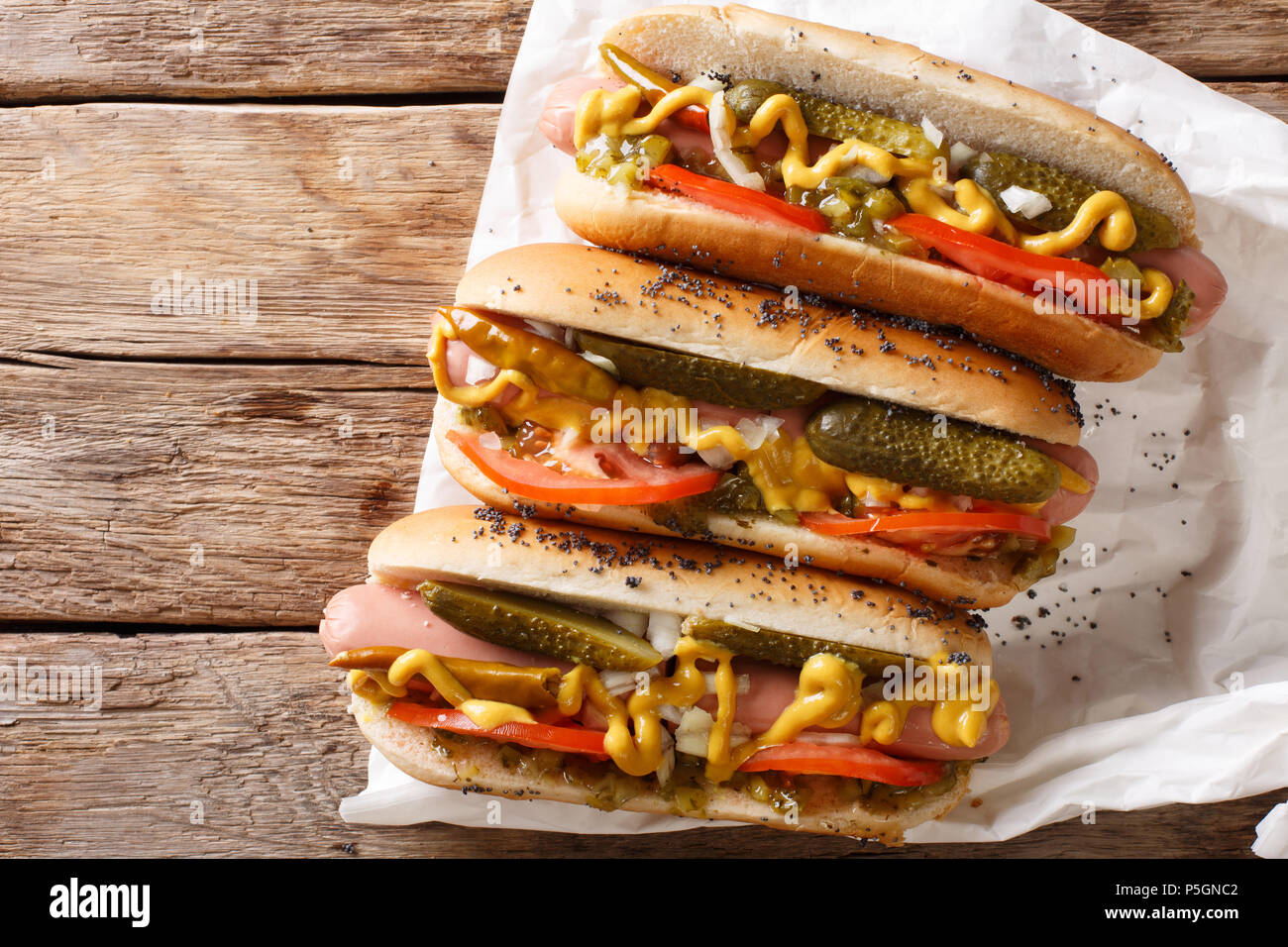 Traditionelle Chicago Style Hot Dog mit Senf, Gemüse und Sauce close-up auf den Tisch. Horizontale Ansicht von oben Stockfoto