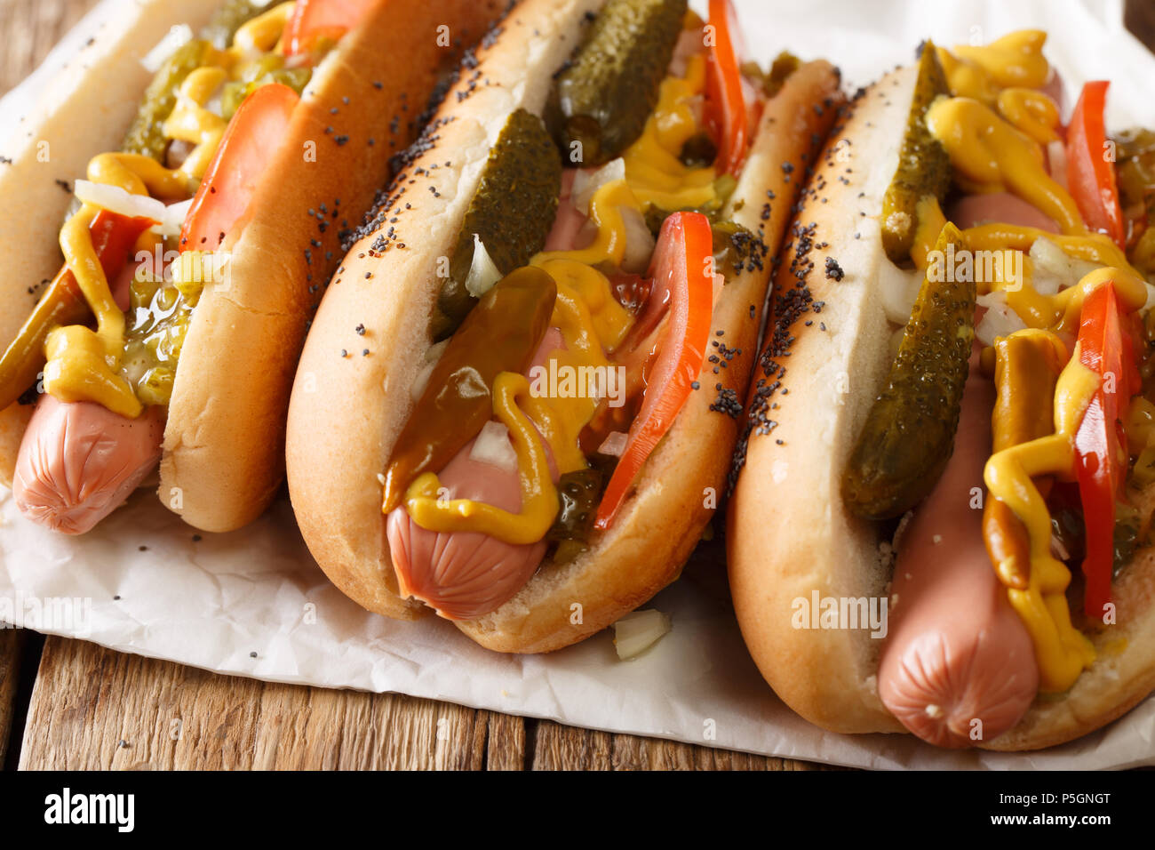 Chicago Style Hot Dog mit Senf, eingelegte Gurken, Tomaten, Zwiebeln und Soße close-up auf dem Tisch. Horizontale Stockfoto