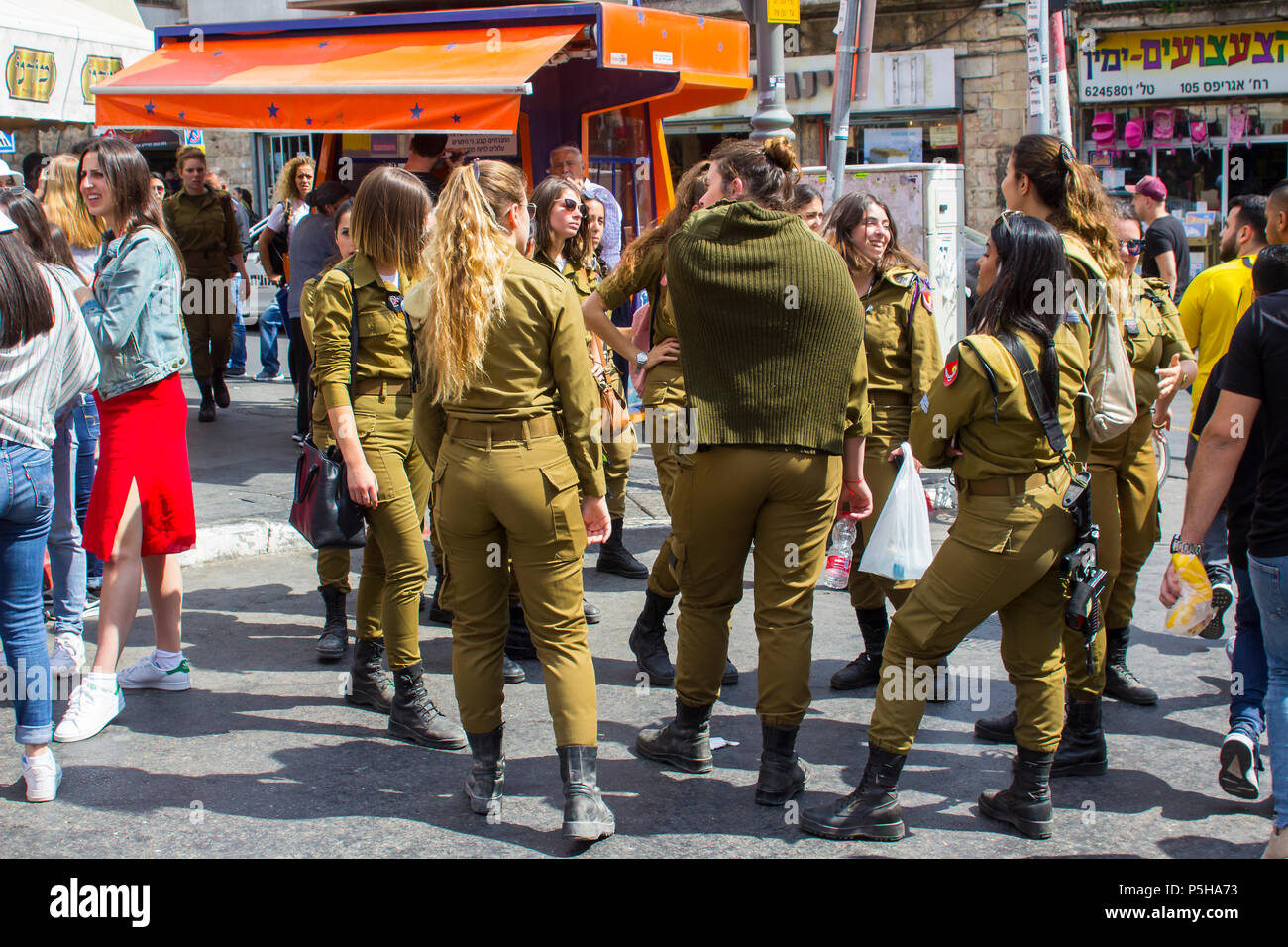 9. Mai 2018 eine kleine Gruppe von Dienstfrei weiblichen Israelischen Armee Wehrpflichtigen mit einem bewaffneten guard Lachen und gemeinsam am Markt Mahane Yehuda Jerusalem chat Stockfoto