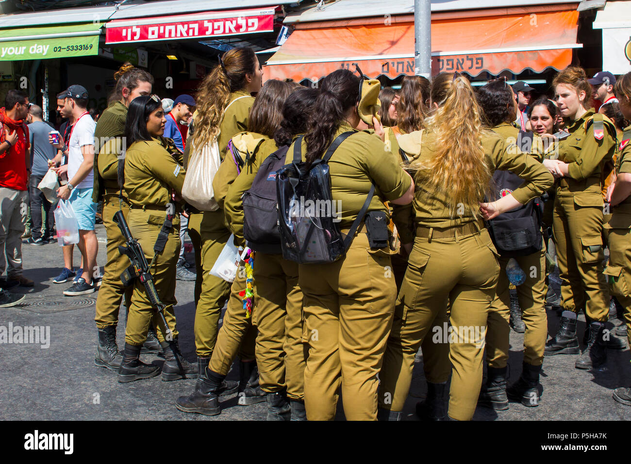 9. Mai 2018 eine kleine Gruppe von Dienstfrei weiblichen Israelischen Armee Wehrpflichtigen mit einem bewaffneten guard Lachen und gemeinsam am Markt Mahane Yehuda Jerusalem chat Stockfoto