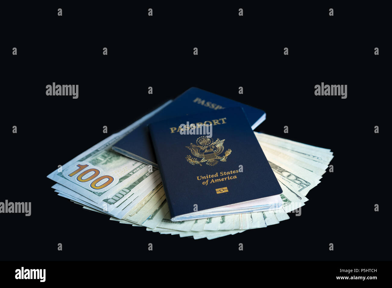 Zwei USA Pässe auf einem Haufen Dollarscheine für Travel Concept Stockfoto
