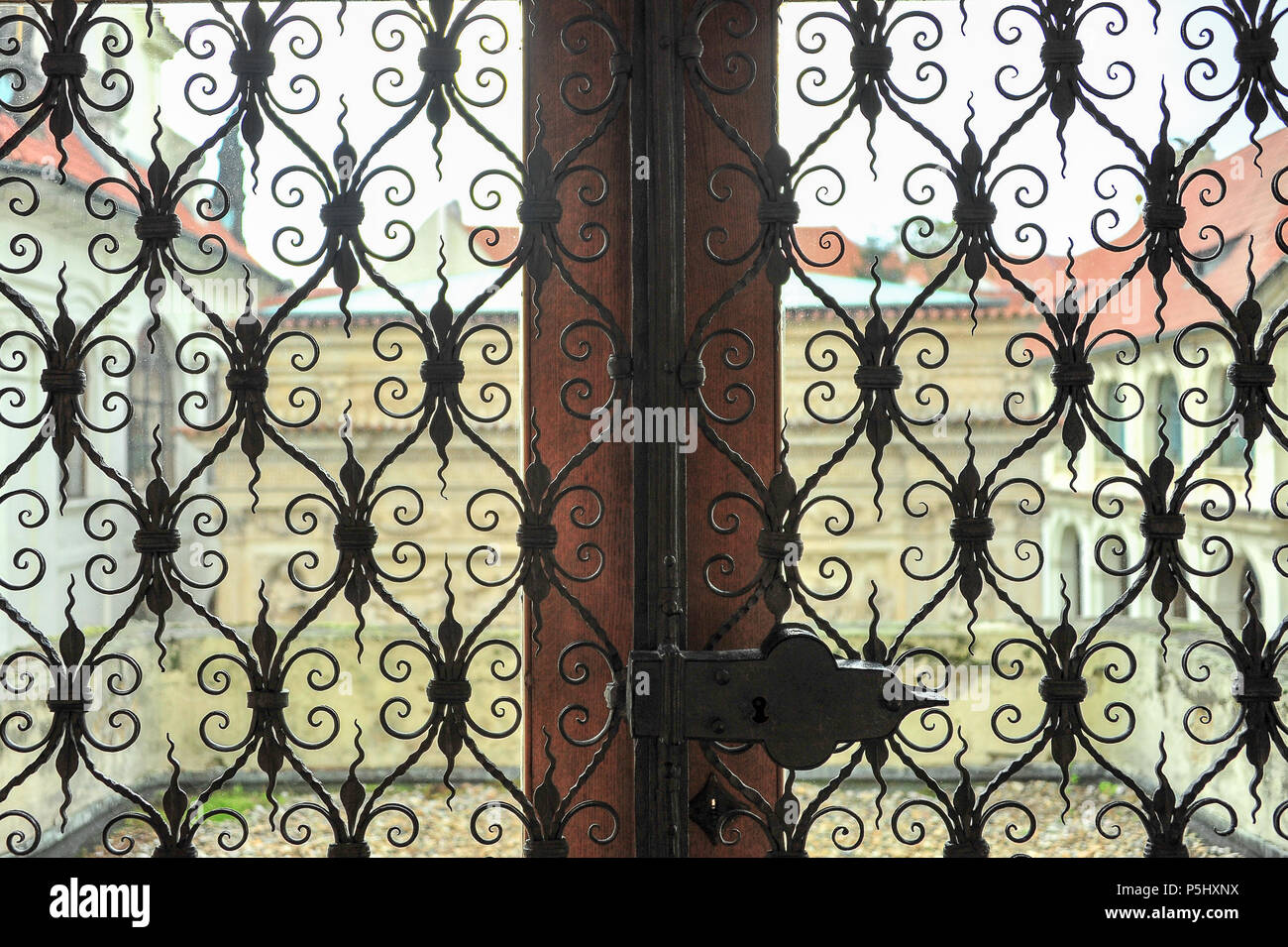 Blick aus dem Fenster an der Muttergottes von Loreto Kirche in Prag. Kunstvollen schmiedeeisernen Bildschirme offenen Innenhof Blick nach außen Stockfoto