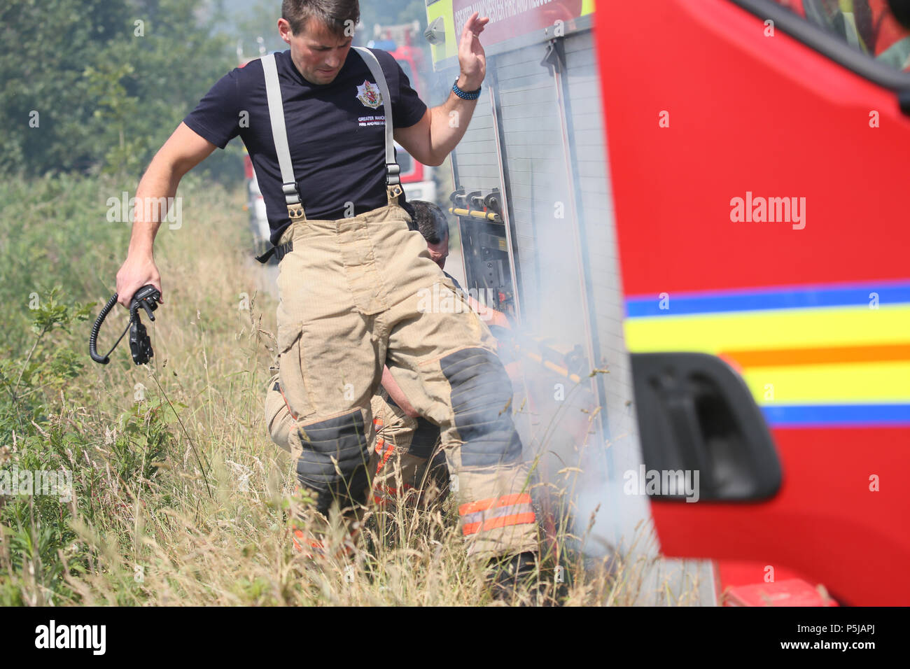 Saddleworth, Großbritannien. 27 Jun, 2018. Feuerwehr Rush aus einem kleinen Feuer, das neben einem Fire Engine, in einen langen Bann von heißem Wetter Land sehr trocken Links hat begonnen hat, Saddleworth Moor, 27 Juni, 2018 (C) Barbara Cook/Alamy leben Nachrichten Stockfoto