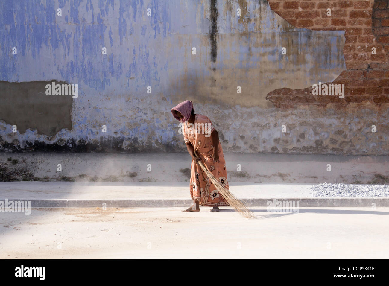 Frau fegt im Innenhof eines alten kolonialen Gebäude verwendet in Ingwer zu handeln. Basar Straße, Kochi, Kerala, Indien. Stockfoto