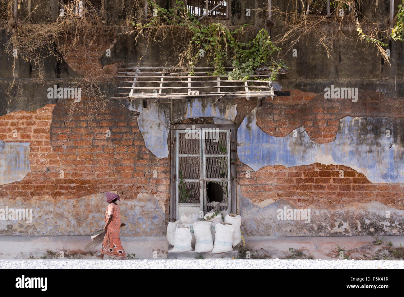 Frau fegt im Innenhof eines alten kolonialen Gebäude verwendet in Ingwer zu handeln. Basar Straße, Kochi, Kerala, Indien. Stockfoto