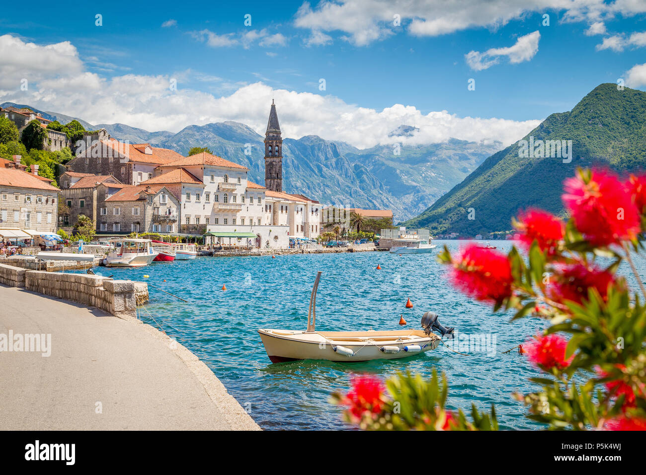 Malerische panorama Blick auf die historische Stadt Perast an der berühmten Bucht von Kotor mit blühenden Blumen an einem schönen sonnigen Tag mit blauen Himmel und Wolken Stockfoto