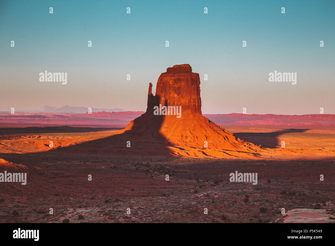 Klassische Ansicht der berühmten Monument Valley mit Schatten des Westens Mitten auf dem Osten Mitten im schönen goldenen Abendlicht bei Sonnenuntergang geworfen werden, Arizona Stockfoto
