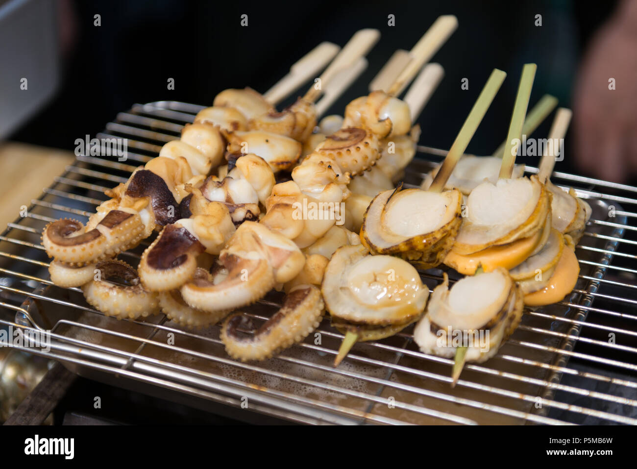 Gegrillte Jakobsmuscheln und Squid an: Kuromon markt Osaka Japan Stockfoto