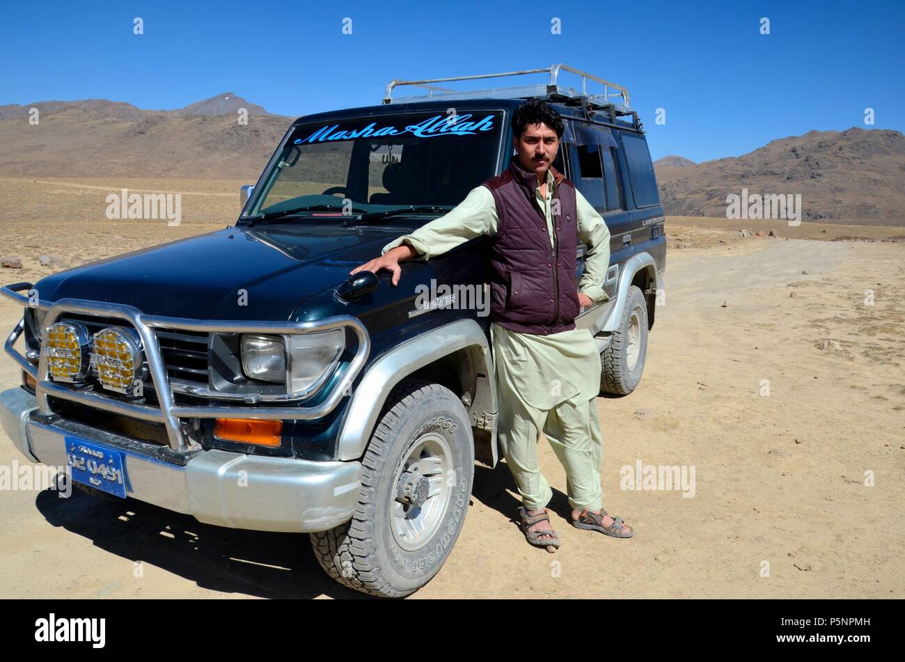 Pakistanische touristische jeep Fahrer in Salwar Kameez wirft mit Jeep an deosai Plains Nationalpark desert Skardu Pakistan Stockfoto