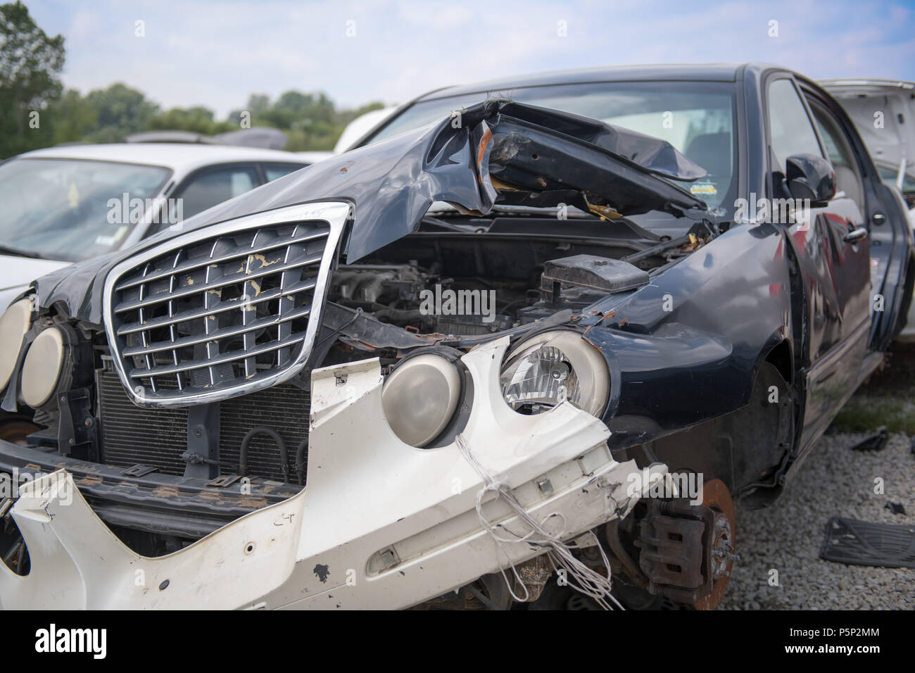 Die Front eines Autos, das über Reparatur hinaus in einem Auto accient zerfleischt wurde, den Stoßfänger auf mit dem Bindfaden Stockfoto