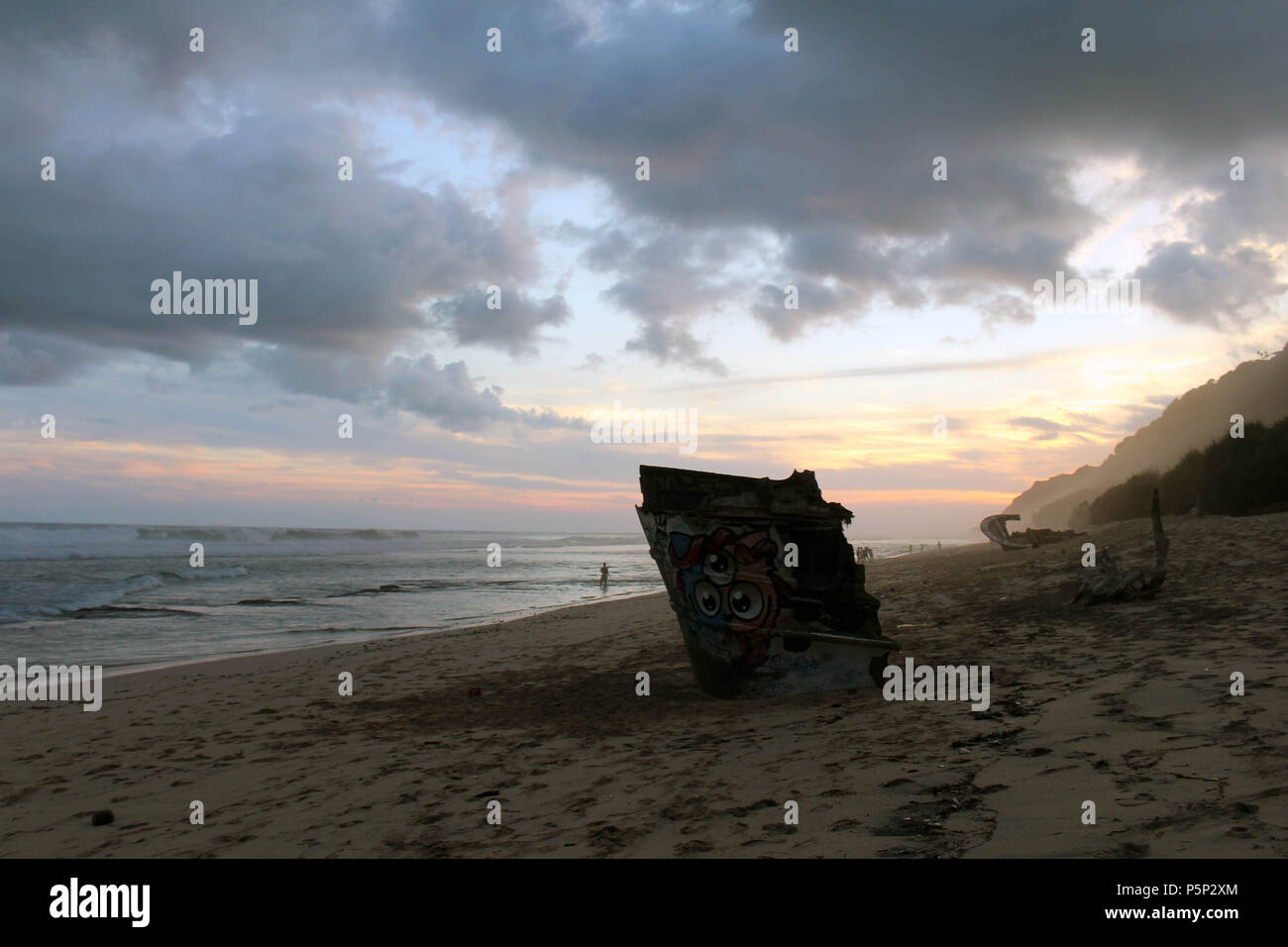 Nyang nyang-Strand und einige kaputte rustikalen Schiffswracks bei bewölkter Sonnenuntergang. In Bali, Juli 2018 berücksichtigt. Stockfoto