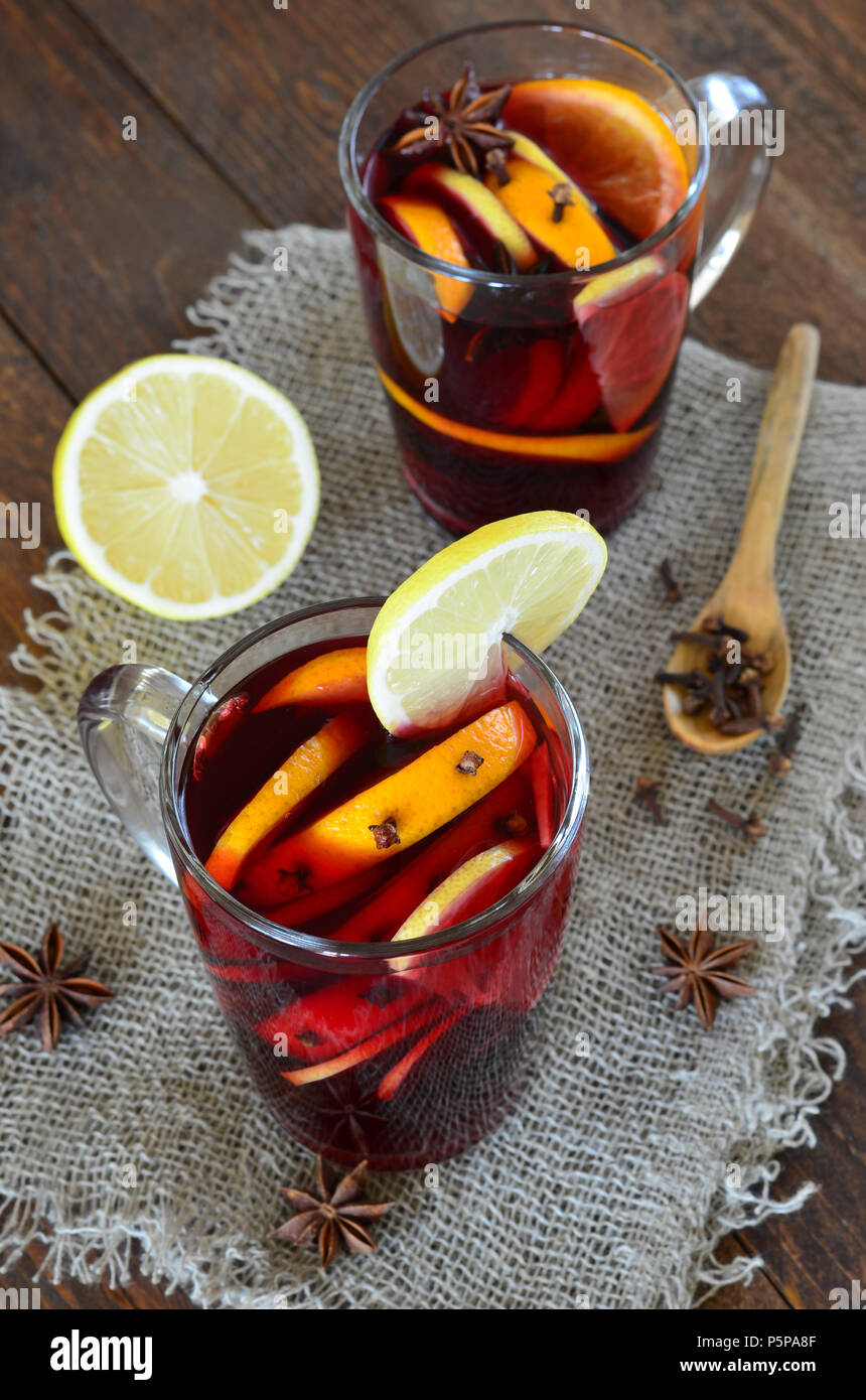 Glühwein mit Orangen- und Zitronenschale auf hölzernen Hintergrund Stockfoto