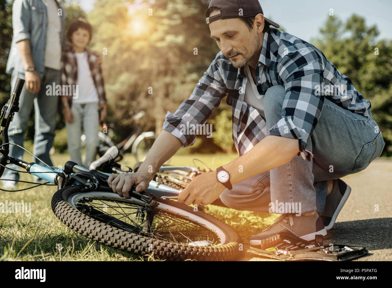 Liebevolle Vater seine Söhne Fahrrad reparieren Stockfoto