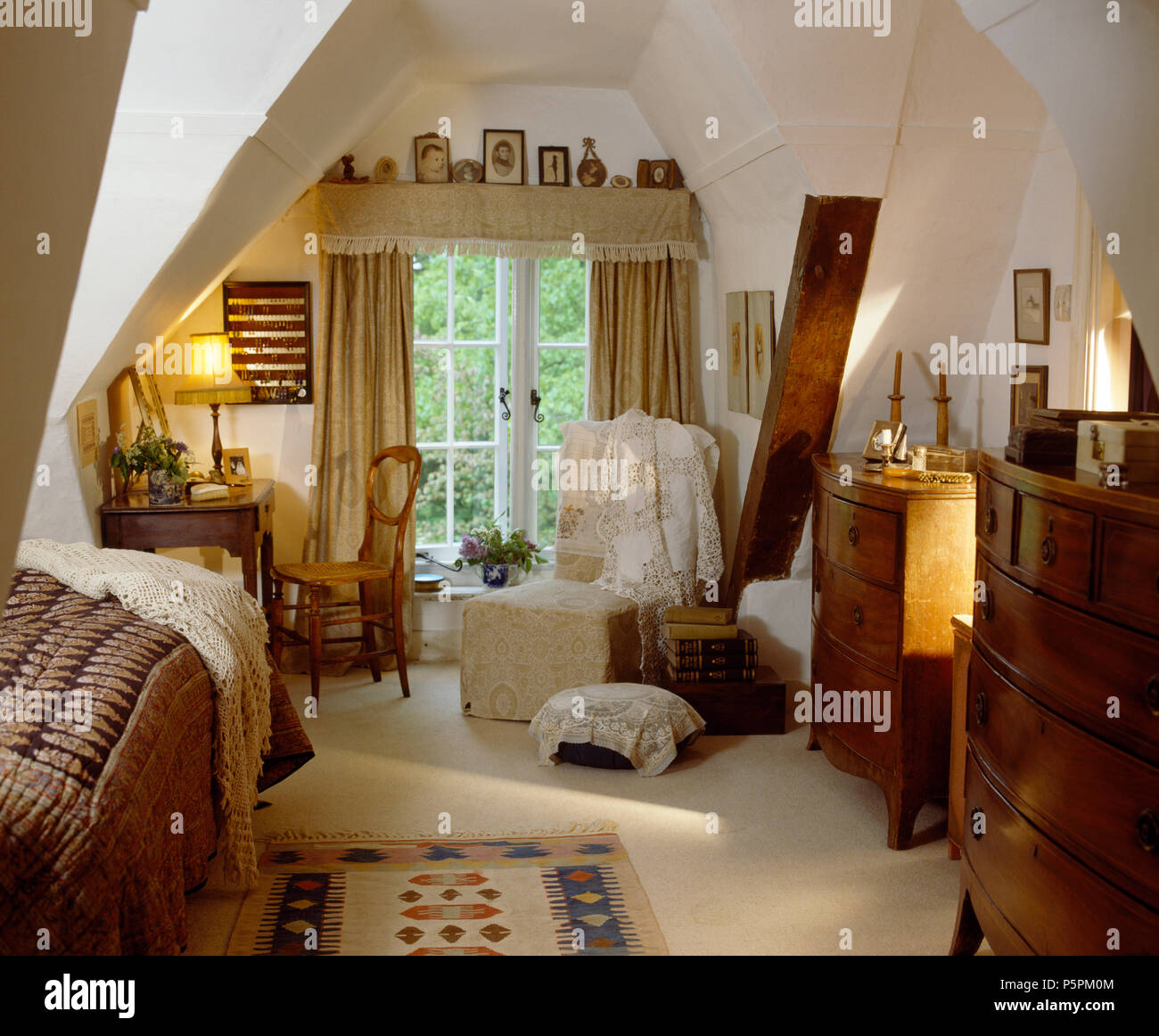 Vintage Schreibtisch und Stuhl neben dem Fenster mit Beige Vorhänge im  Schlafzimmer im Dachgeschoss mit weißer Teppich und ein paar antike Kommode  Stockfotografie - Alamy