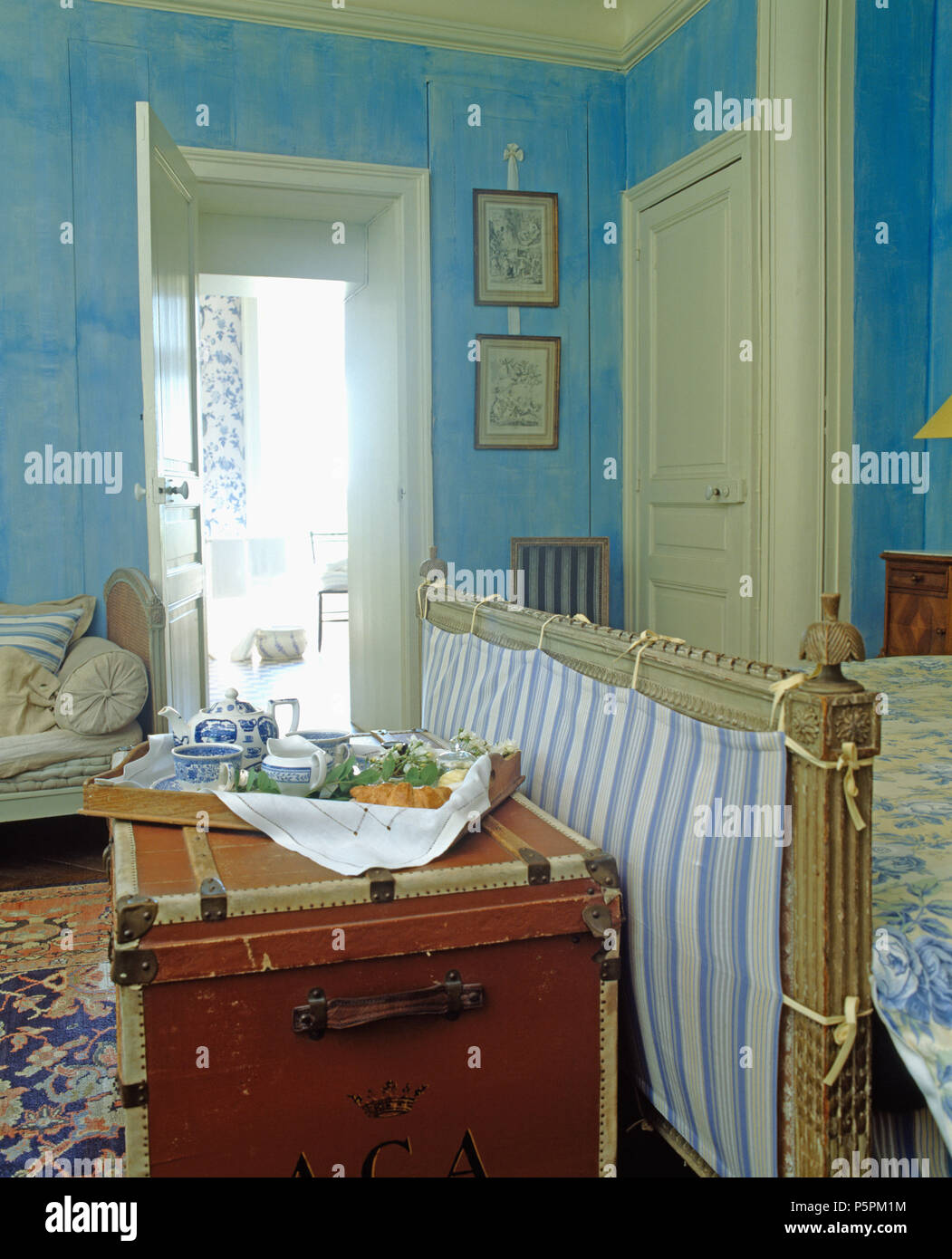 Frühstückstablett mit Blau + weiß China auf Vintage trunk am Fuße des Bettes im Blauen Land Schlafzimmer Stockfoto