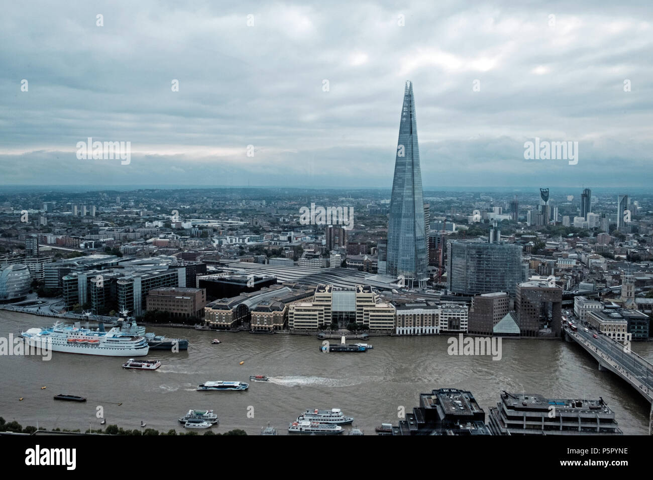 Luftaufnahme der Shard, umliegenden Londoner Gebäude, kommerzielle Wolkenkratzer und die Themse. Bewölkter Himmel. Drucken Raum. Boote auf dem Fluss. Sep 2017 Stockfoto