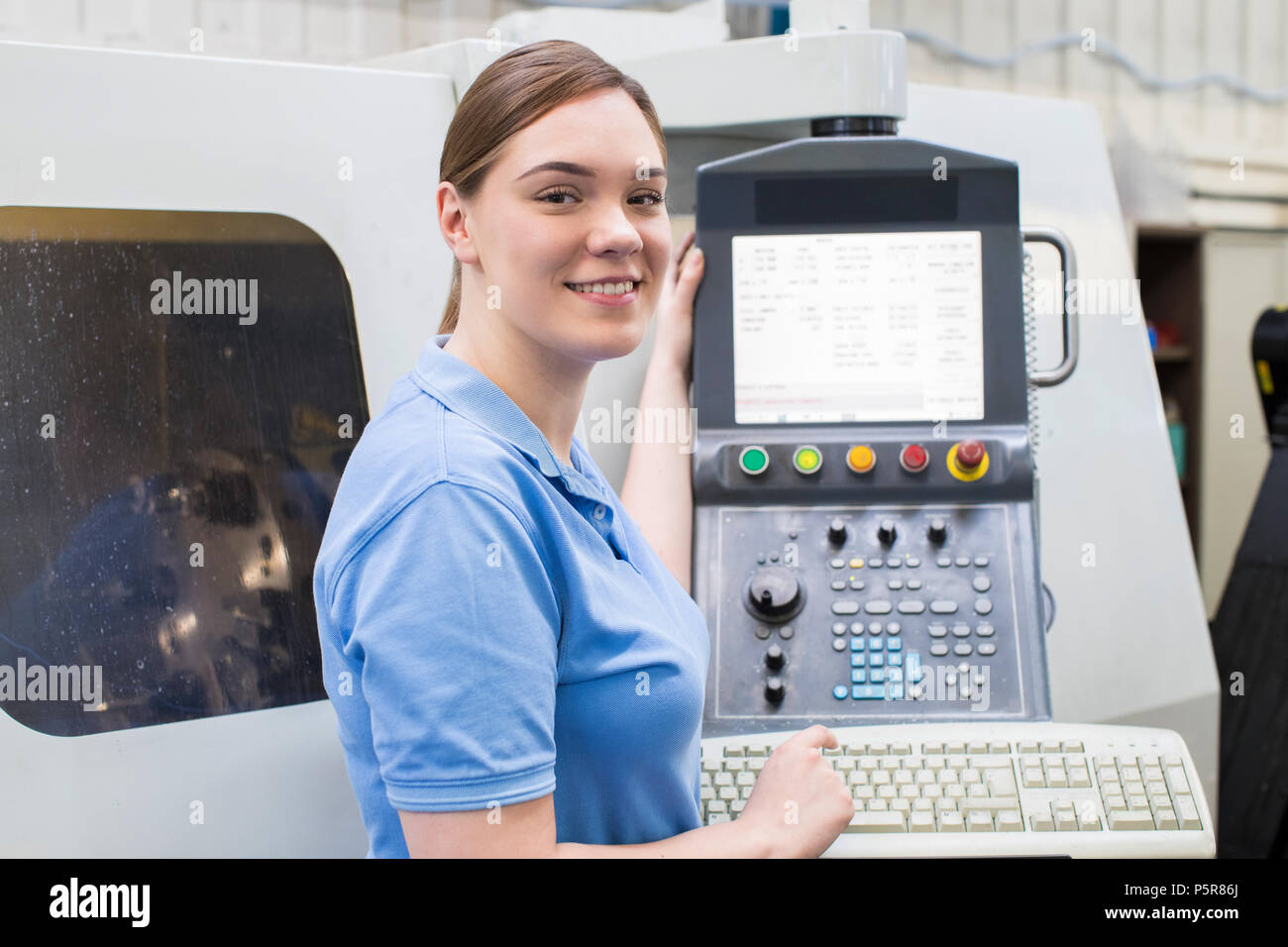 Portrait von weiblichen Lehrling Ingenieur der CNC-Maschine im Werk Stockfoto Portrait von weiblichen Lehrling Ingenieur der CNC-Maschine im Werk Stockfoto