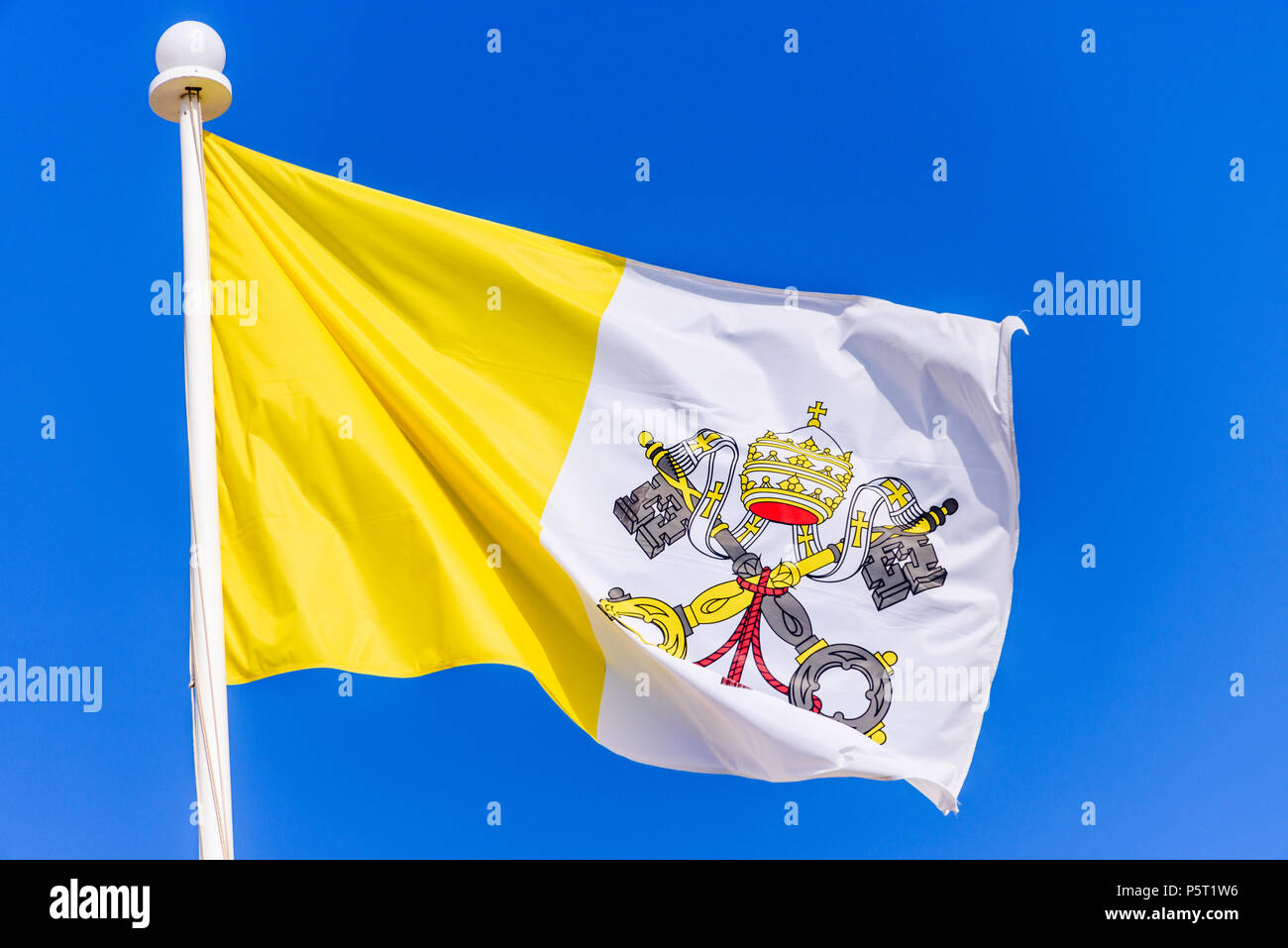 Die Flagge der Vatikanstadt vor blauem Himmel. Stockfoto