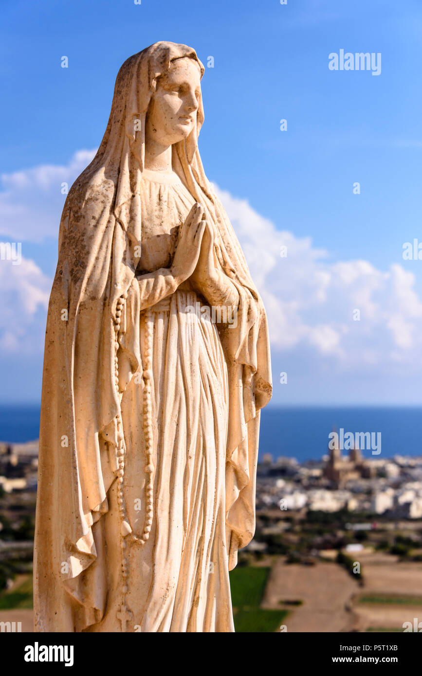 Eine Statue der Jungfrau Maria steht an der Spitze eines Hügels in Gozo, Malta. Stockfoto