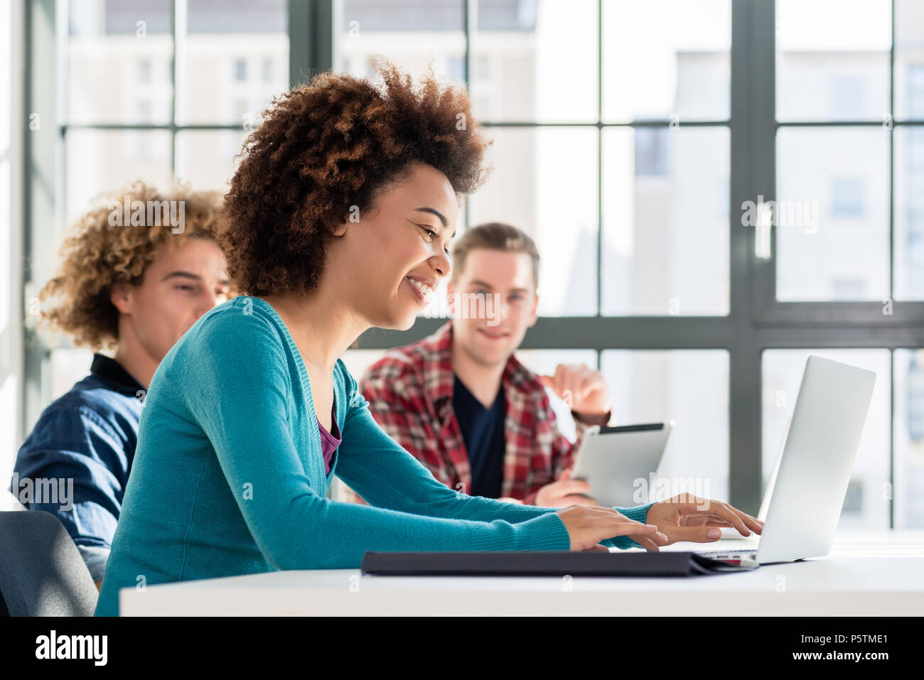 Student lächelnd, während Sie einen Laptop für On-line-Informationen Stockfoto
