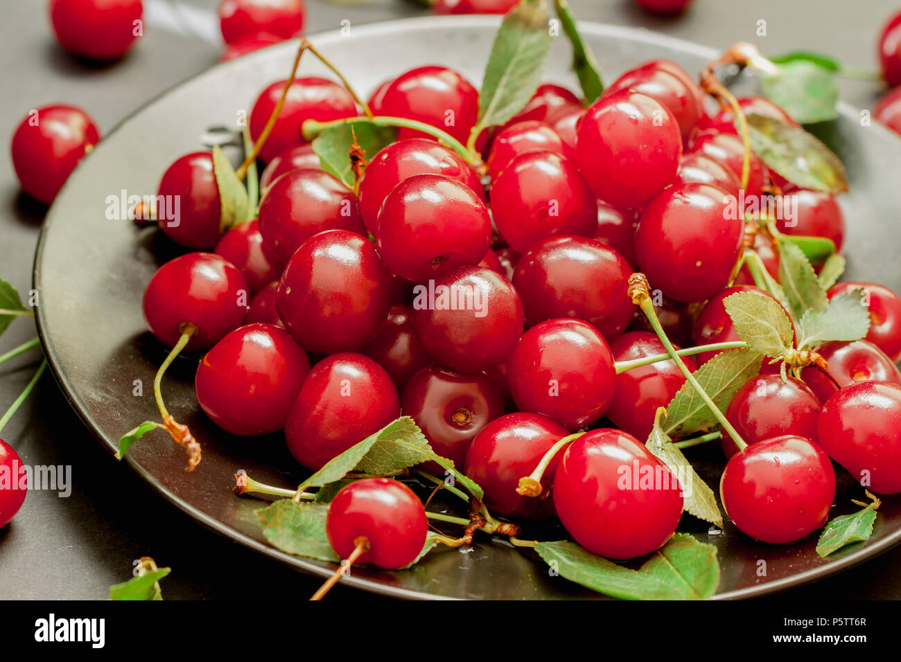 Schwarze Platte mit lecker, saftig, helle Kirschen Stockfotografie - Alamy