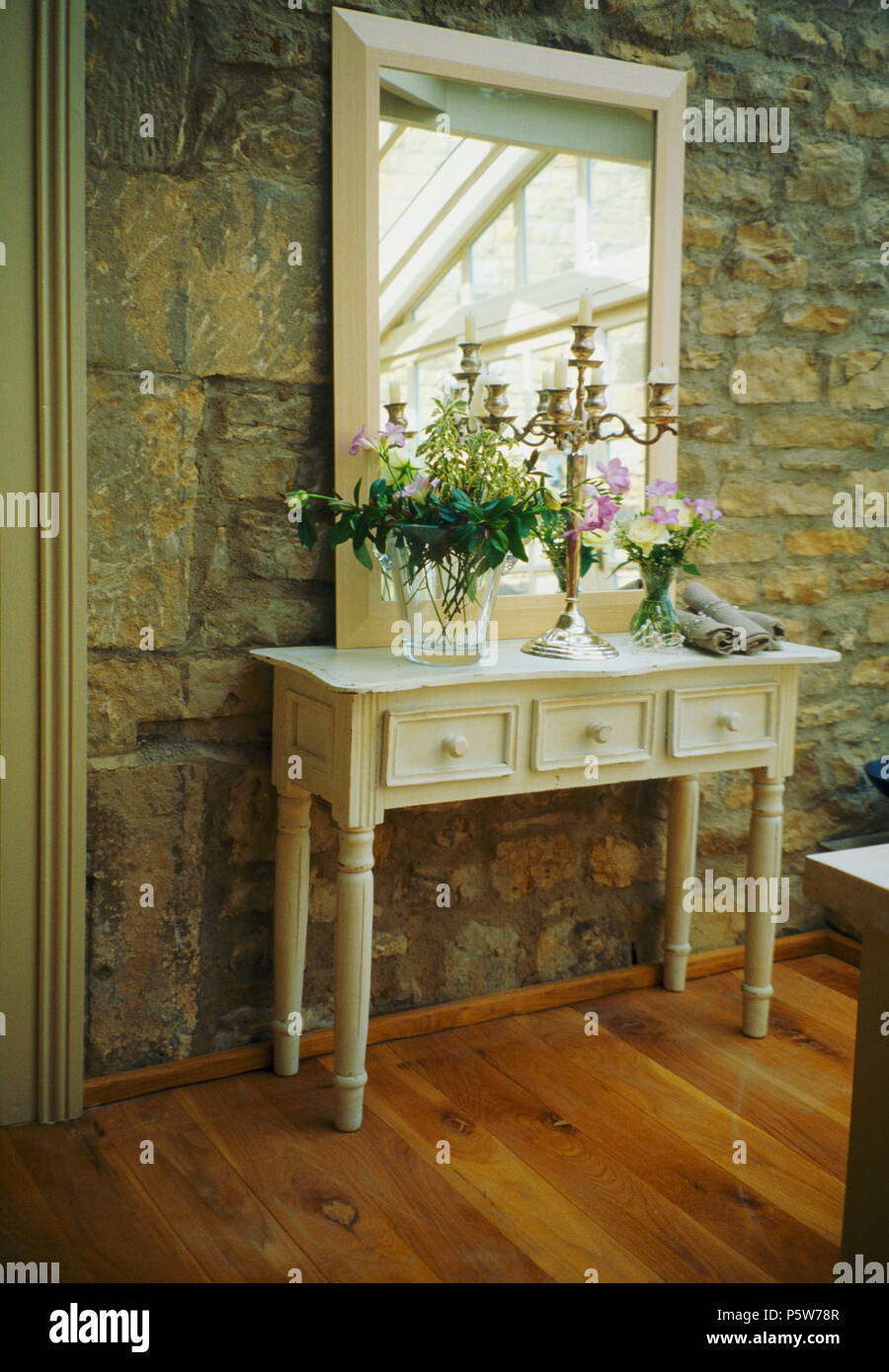 Spiegel über weiße Konsole Tisch gegen Stein Wand im Land Halle Stockfoto