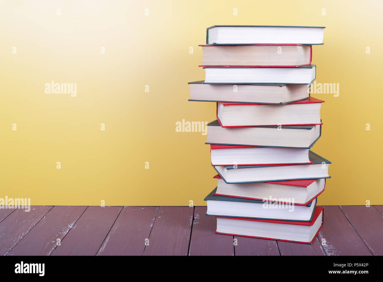 Wissenschaft und Bildung - Stapel Gruppe von bunte Bücher auf dem Holztisch und gelben Hintergrund. Stockfoto