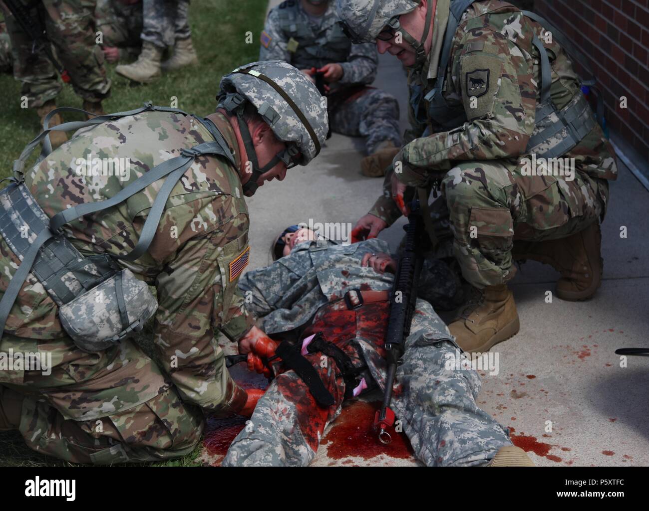 Us-Soldaten mit der South Dakota Army National Guard Praxis tourniquet Anwendung auf einem simulierten Unfall als Teil der Bekämpfung der Lebensretter Ausbildung an der West Camp Rapid, Rapid City, SD, Juni 11, 2018, 11. Juni 2018. Die goldenen Coyote Ausbildung Übung ist eine dreiphasige, Szenario-driven Übung in den Black Hills von South Dakota und Wyoming, mit dem Kommandanten auf der Mission wesentliche Anforderungen der Aufgabe, Krieger Aufgaben und Übungen zu konzentrieren. (U.S. Armee Foto von Pfc. James Smith). () Stockfoto