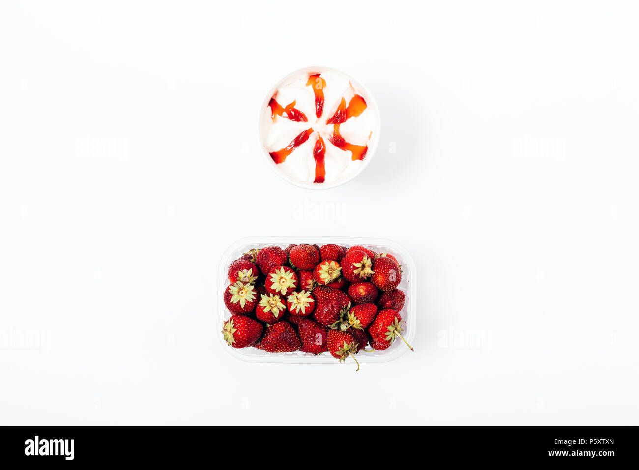 Eis mit topping Sirup und eine Schachtel mit frischen Erdbeeren, Ansicht von oben. Flach minimale Zusammensetzung der gefrorenen Desserts und roten Beeren auf einem weißen zurück Stockfoto