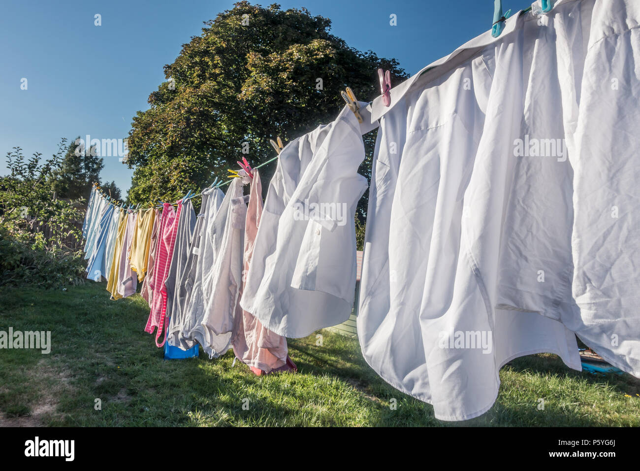 Kleidung hängend auf einer Wäscheleine in einem Wohngebiet Garten zu trocknen. Stockfoto