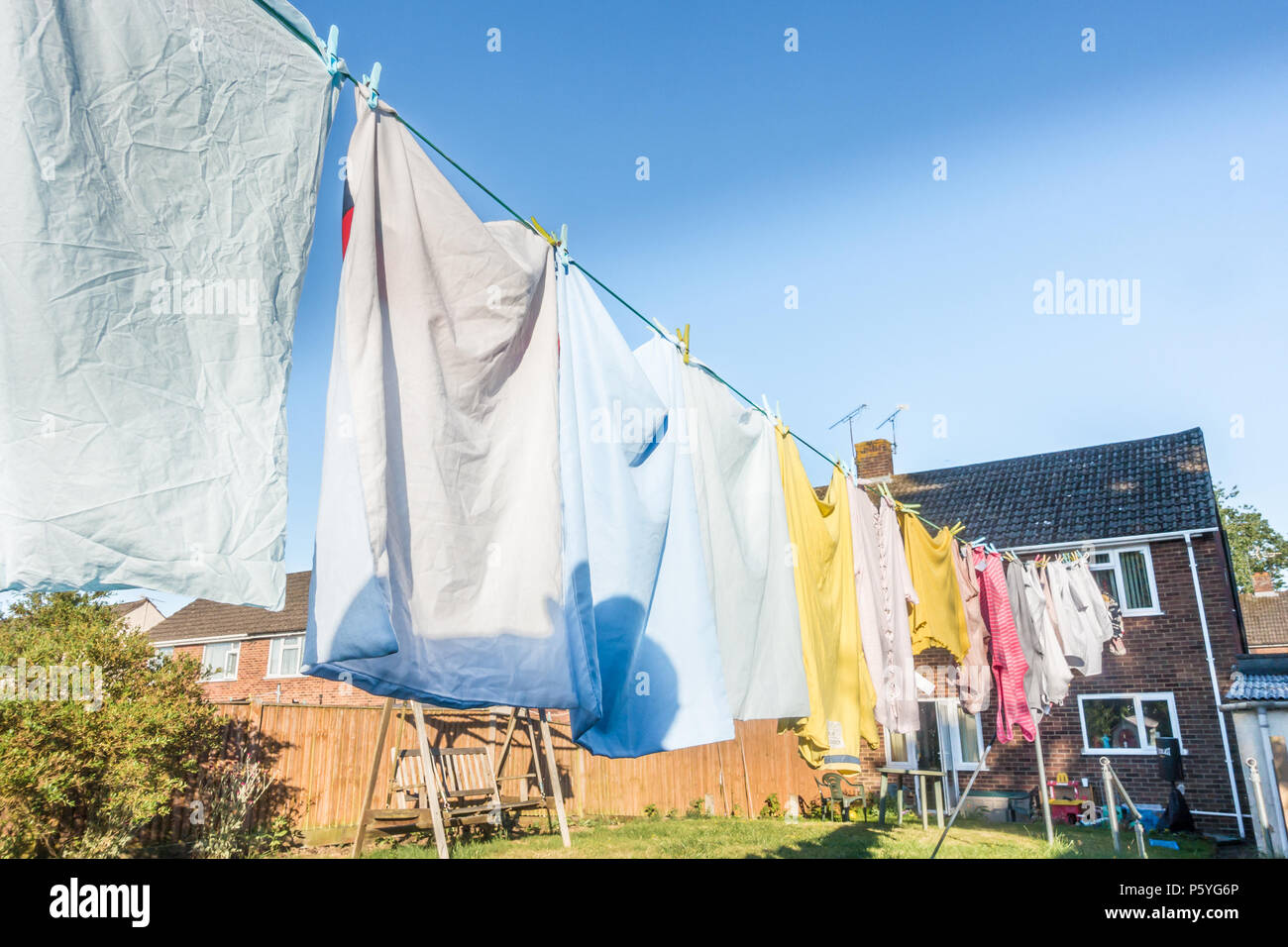 Kleidung hängend auf einer Wäscheleine in einem Wohngebiet Garten zu trocknen. Stockfoto