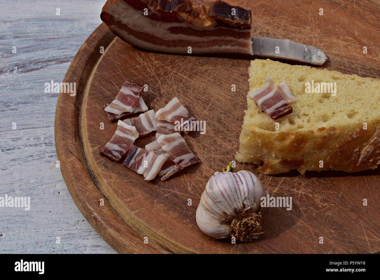 Leckeren Teller mit geräuchertem Speck, Knoblauch und Brot mit rustikalen Holzmöbeln Hintergrund/Traditionelle Balkan Essen Stockfoto