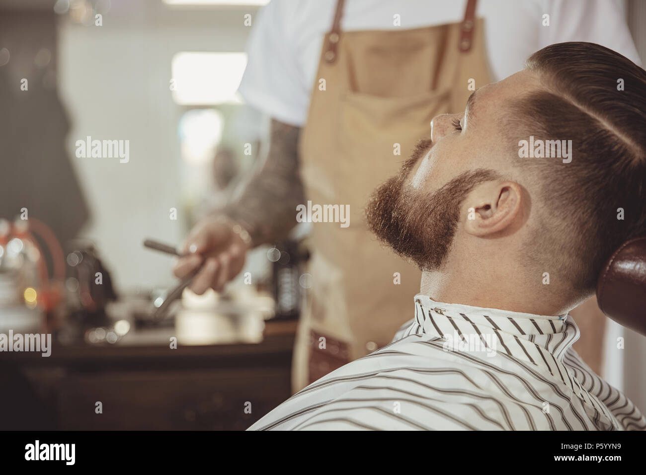 Mann mit einem Bart wartet mit einem Rasiermesser in einem Friseursalon Rasur. Foto im Vintage Style Stockfoto