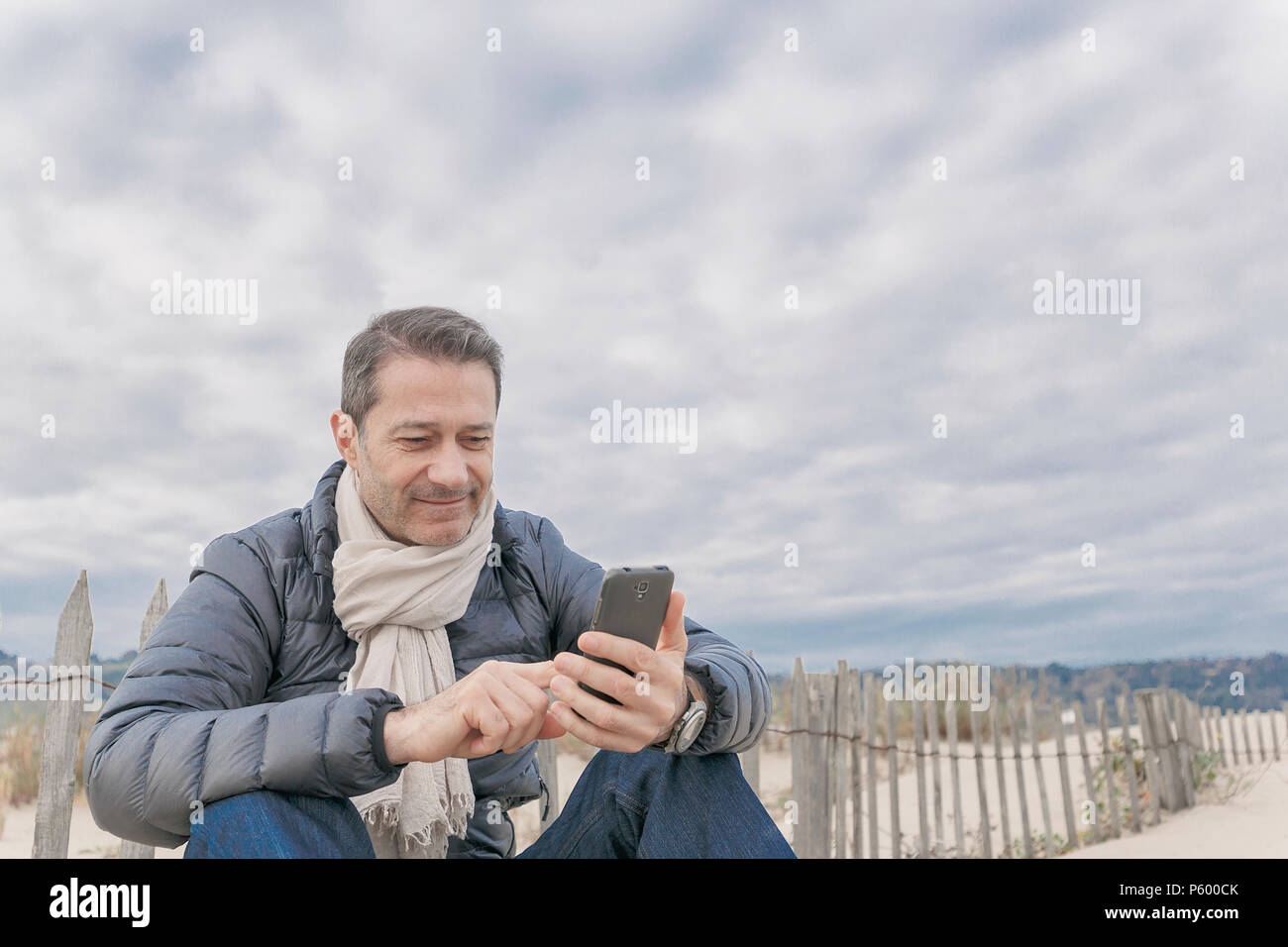 Französischen Mann am Strand mit Telefon Stockfoto