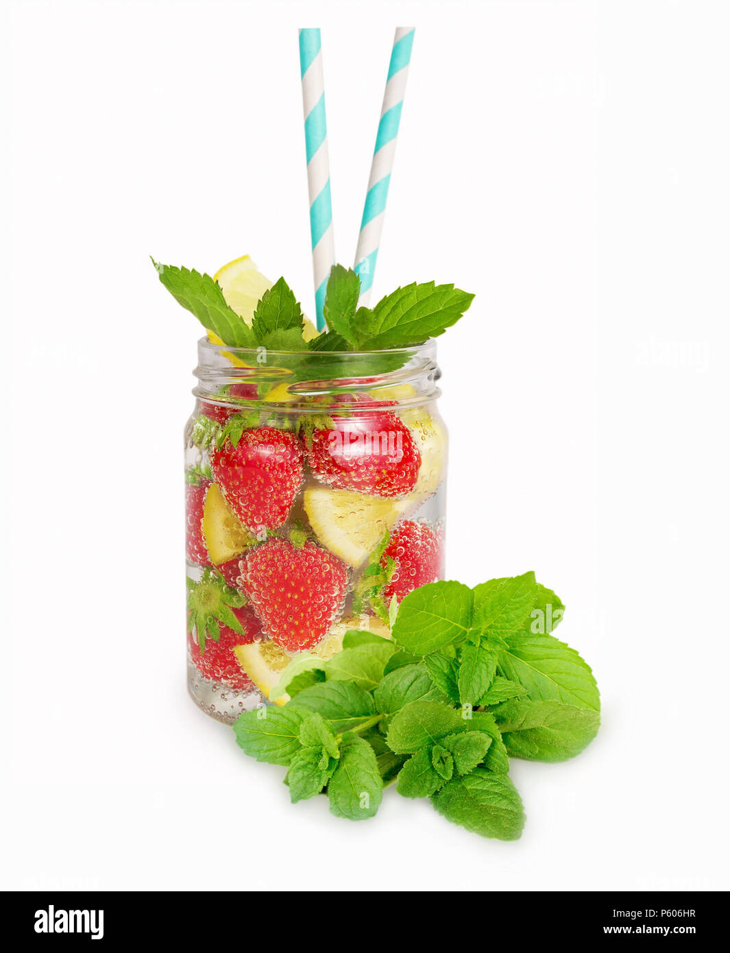 Erdbeer Limonade mit Zitronenscheiben. Drink in einem Glas mit einem Bündel Minze. Hausgemachte Limonade auf weißem Hintergrund. Getränke für eine Partei. Stockfoto
