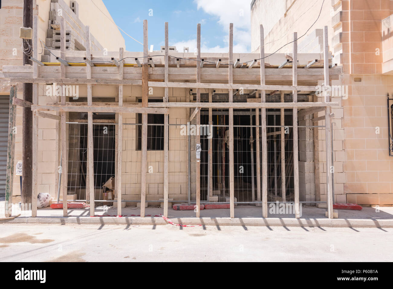 Traditionelle Holzpfähle als Unterstützung Gerüst an einem Haus home Baustelle in Malta verwendet. Stockfoto