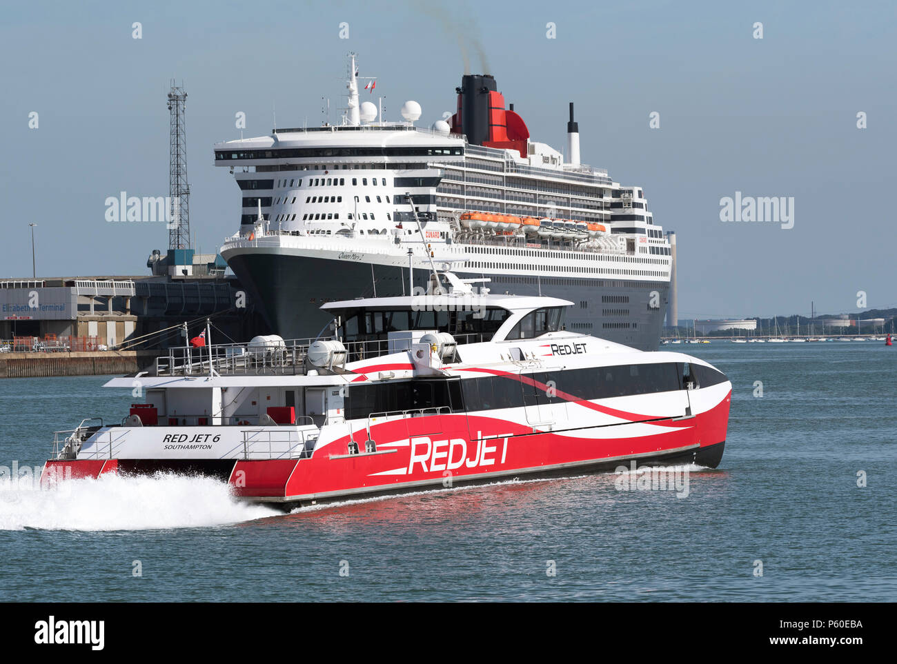 Southampton, England, UK. 2018. Besetzt Versand Kanal von Southampton Hafen. Schnelle Fähre für das Iow vorbei an Queen Mary II Kreuzfahrtschiff gebunden. Stockfoto